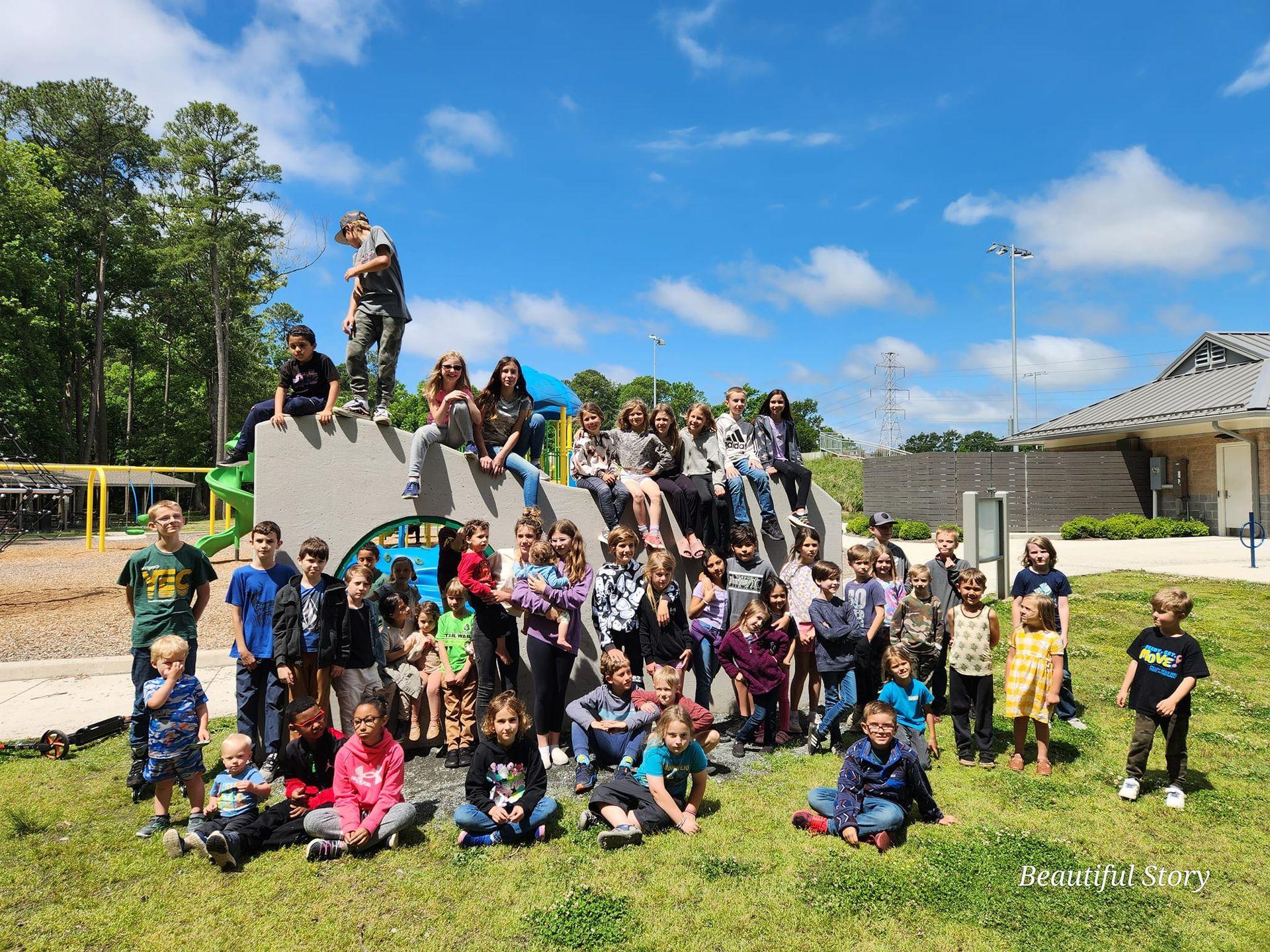 Large group of children gathered on and around a playground structure on a sunny day.