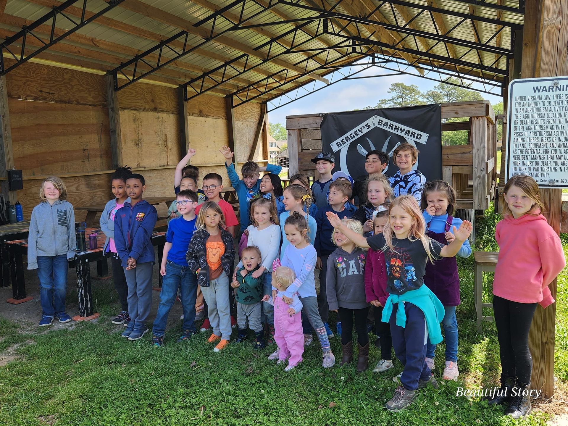 Group of children posing together under a covered outdoor area at Bergey's Barnyard farm.